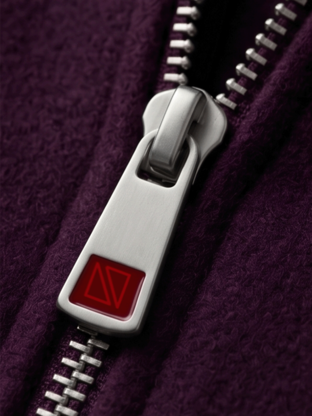 Brushed metal zipper slider with inlaid enamel Duevon monogram